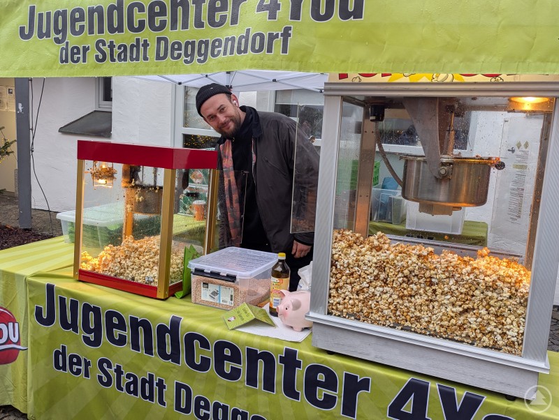 Knusprig-krosses Popcorn versüßte den Besuch der Kinderweihnacht zusätzlich. Popcorn-Stand mit Mitarbeiter des Deggendorfer Jugendzentrums 4You