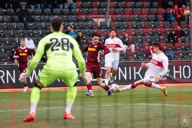 Ein Regensburger Angreifer zieht im Strafraum ab, w&auml;hrend ein Stuttgarter Verteidiger gr&auml;tscht und der Torwart bereitsteht