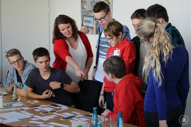 „Besuch bei Fraunhofer ESK – 3“: Der Freyunger Schüler Peter Schulz (ganz rechts im Bild) lauscht gespannt den Anweisungen der Expertin bei der praktischen Übung zu Ampelschaltungen.