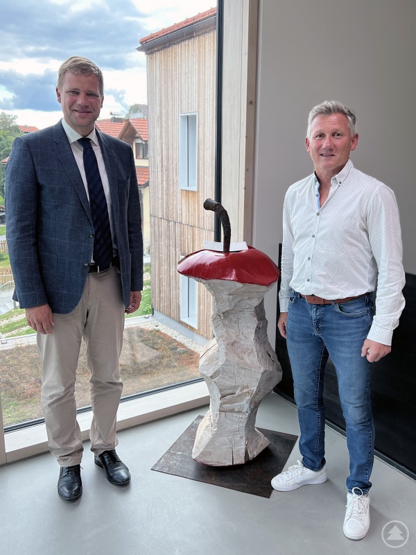 Holzkunst im Holzbau: Bezirkstagspräsident Dr. Olaf Heinrich (links) traf sich mit Neuschönaus Bürgermeister Alfons Schinabeck zum Erfahrungsaustausch über die Holzgemeinde.