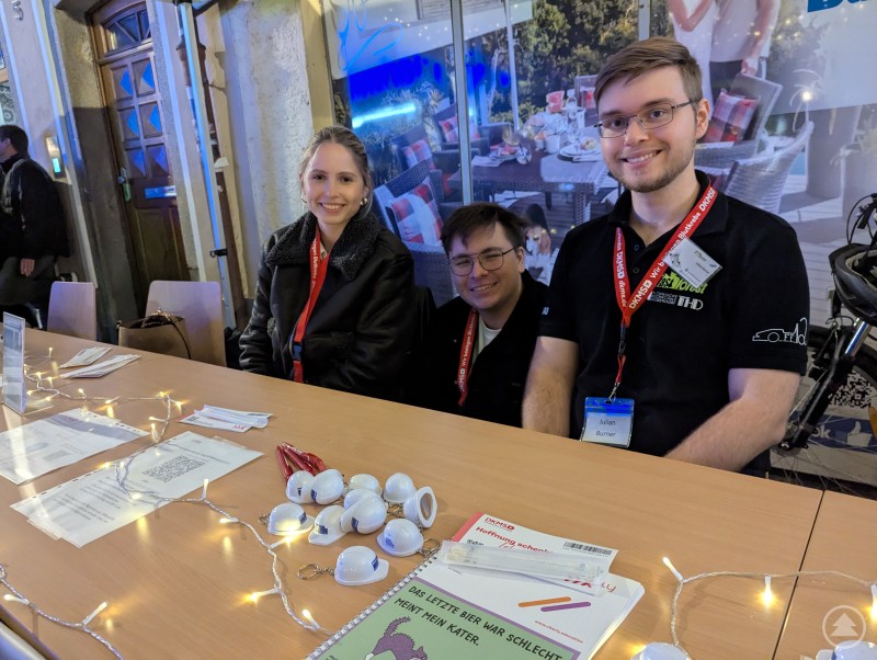 Beim Stand des Studentischen Konvents konnte man sich über deren Arbeit informieren und sich bei der DKMS typisieren lassen. Drei Studierende lächeln in die Kamera