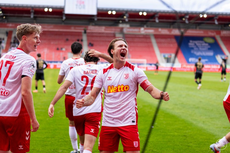 Spieler des SSV Jahn Regensburg jubeln lautstark, einer schreit seine Freude heraus.