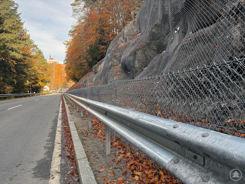 Blick entlang der Kreisstraße FRG 32 mit neu installierten Schutznetzen und Felsbefestigungen am Straßenrand.