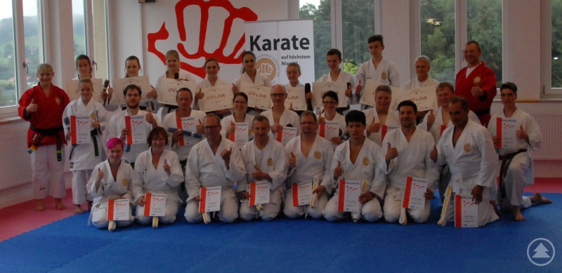 Die Prüflinge zusammen mit den Prüfern Ramona Gruber (stehend links, rote Jacke) und Paul Gruber (stehend rechts, rote Jacke)