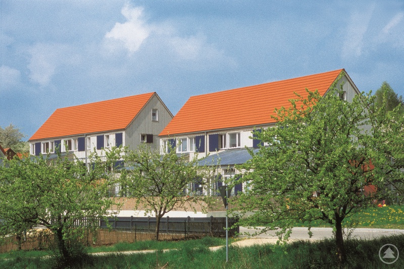 Gemeinde Haundorf, Lkr. Weißenburg-Gunzenhausen: Die Wohnhausgruppe in der Gemeinde Haundorf in Mittelfranken stellt ein zeitgemäßes Beispiel für flächensparendes Bauen im ländlichen Raum dar. Die beiden langgestreckten Wohngebäude, die jeweils drei Wohneinheiten aufnehmen, übersetzen zugleich die Merkmale der fränkischen Kulturlandschaft in die Gegenwart.