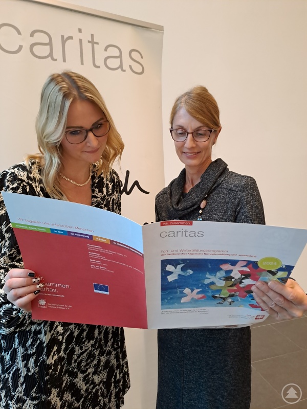 Die neue Caritas-Mitarbeiterin der Heilpädagogischen Tagesstätte Pocking, Francesca Hass, erkundigt sich bei Karin Schlappinger (re.) aus der Bildungsabteilung nach Kursen für Einsteiger*innen.