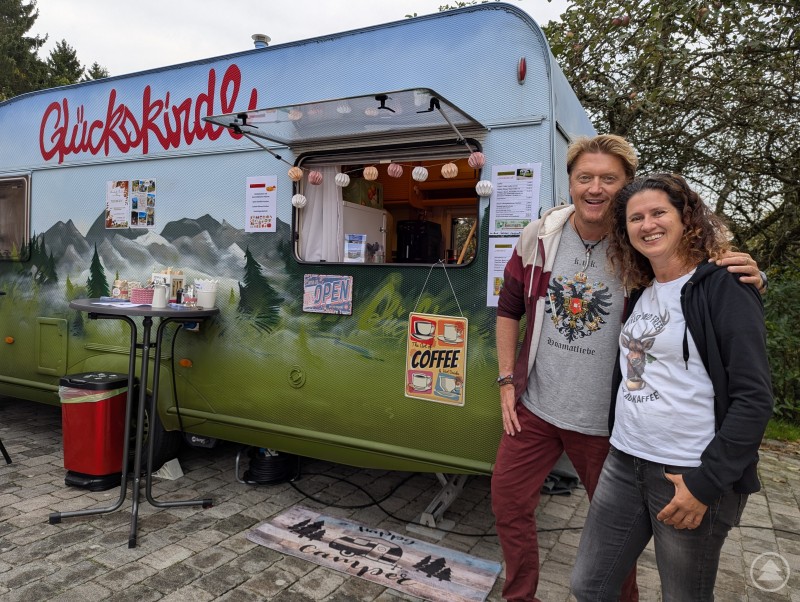 Erwin Neuherz und Christine Resch vor Wohnwagen des Campercafé Glückskindl
