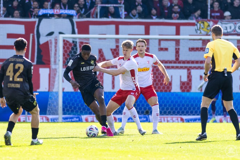 Zwei Regensburger Spieler versuchen, einem Stuttgarter den Ball abzunehmen.