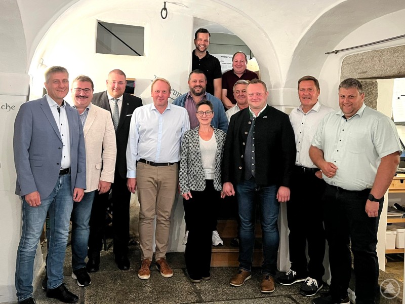 v.L. Tassilo Pichlmeier, Max Ertl (wieder MU- und CSU-Mitglied), Christoph Weishäupl, Mario Dumps, Siegfried Freund, Simon Stockinger, Sonja Kozeny, Josef Demm (hinten), Herbert Schiller, Stefan Behringer (MU-Kreisvorsitzender), Gerhard Wimmer, Armin Urmann Auf dem Bild sind die genannten Personen bei einem gemeinsamen Gruppenfoto in einem hellen Innenraum zu sehen. Die Gruppe steht dicht beieinander und blickt geschlossen in die Kamera. Die Kleidung reicht von leger bis gepflegt-elegant, was auf ein offizielles Treffen oder eine verbandliche Zusammenkunft hindeutet. Die Anordnung entspricht der Bildunterschrift mit einer Person im hinteren Bereich, ansonsten stehen alle Beteiligten nebeneinander und vermitteln eine offene, freundliche Atmosphäre.