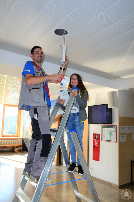 Die Realschülerin Angelina Grimm hilft bei Elektro Loibl, Grafenau, im Rahmen der Was-will-ichwerden- Woche, die Deckenbeleuchtung an der eigenen Schule zu überprüfen.