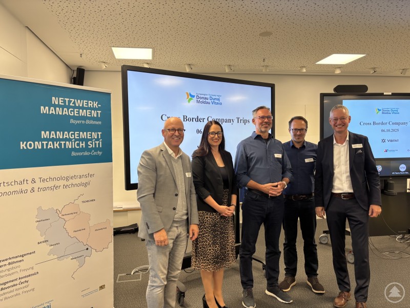 Von links: Kaspar Sammer, Jaroslava Pongratz, Franz Ederer, Alexander Schießl und Markus Pannermayr beim Cross Border Company Trip am 6. Oktober 2025 bei Völkl in Straubing. Fünf Personen stehen nebeneinander in einem Konferenzraum vor großen Bildschirmen, die den Titel „Cross Border Company Trips“ zeigen. Links befindet sich ein Banner mit der Aufschrift „Netzwerkmanagement Bayern–Böhmen“. Alle Personen lächeln in die Kamera, die Atmosphäre wirkt professionell und freundlich.