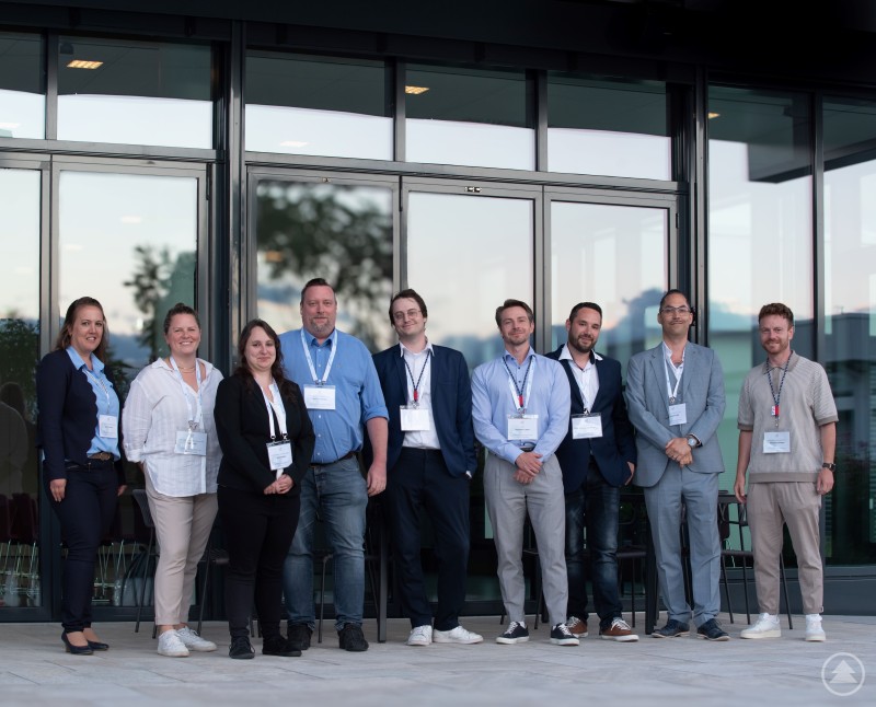 Das Team vom GreG FRG – Jasmin Binder (l.), Stephanie Fichtl (2. v.l.) und Wirtschaftsförderer Johannes Gastinger (r.) – mit dem Gastgeber Christoph Cegla (2. v.r.) und den Referenten (ab 3. v.l.) Stefanie Merz, Bastian Skotzek, Kevin Gerber, Ben Luther und Christian Uhrmann. Neun Personen stehen nebeneinander vor einem modernen Glasgebäude. Alle tragen Namensschilder, einige Business- oder Freizeitkleidung. Es handelt sich um die Organisatoren und Referenten der Veranstaltung zur Cyber Security in Grafenau.