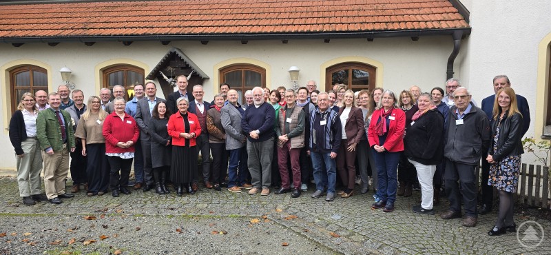 Eine starke Gemeinschaft bilden die Caritas-Ortsvereine. Hier die Vertreter:innen mit Vorstand Stefan Seiderer und Abteilungsleiterin Ingrid Aldozo beim Jahrestreffen. Eine große Gruppe von rund 40 Personen steht vor einem Gebäude mit gelbem Putz und roten Dachziegeln. Sie lächeln in die Kamera, einige tragen Namensschilder.