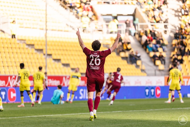 Jubel nach dem Treffer: Der SSV Jahn feiert das 2:0 und einen verdienten Auswärtssieg beim Traditionsverein Alemannia Aachen. Ein Regensburger Spieler mit der Rückennummer 26 jubelt mit erhobenen Armen vor der Gästekurve, nachdem ein Tor erzielt wurde. Die Spieler von Alemannia Aachen wirken enttäuscht, das Stadion ist in gelb-schwarz gehalten.