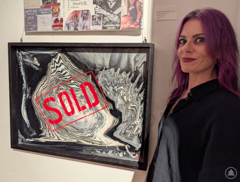 Mit einem Augenzwinkern bestach auch SOLD von Ella Neuner als Kunstwerk aus Acryl und Mixed Media auf Malplatte. Ella Neuner vor ihrem Acryl und Mixed Media Bild auf Malplatte