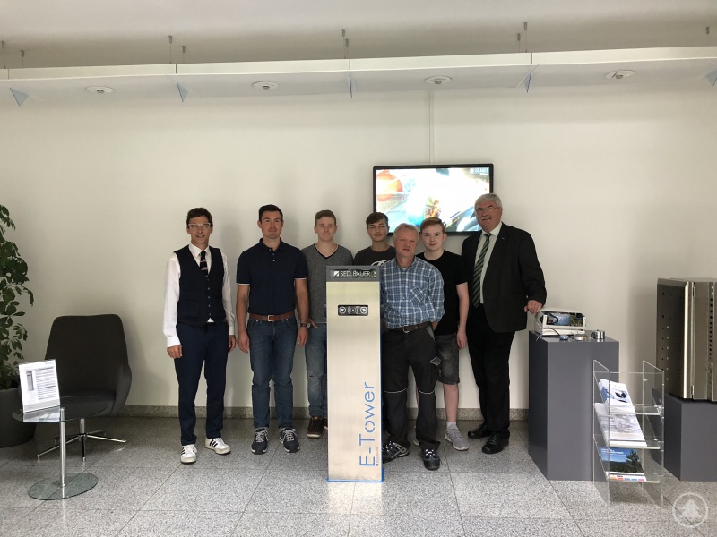 Schulleiter Günther Schwarzbauer (rechts), die Ausbilder der Sedlbauer AG (2. von links und 3. von rechts), Regionalmanager Stefan Schuster (links) und die teilnehmenden Praktikanten vor einer Sedlbauer-Ladesäule.
