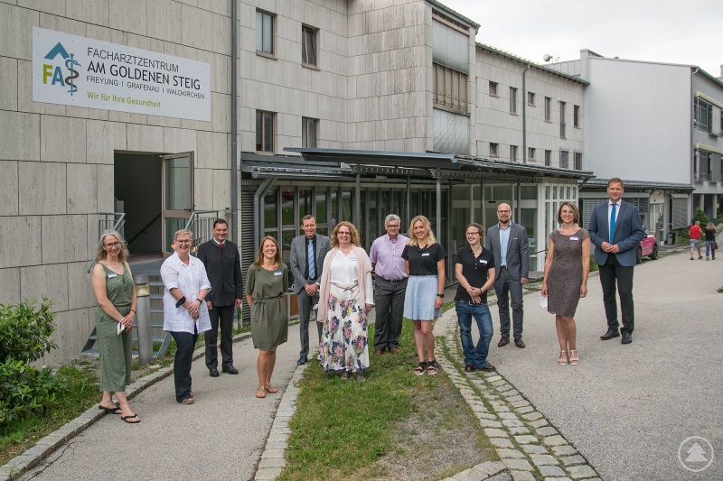 Bezirkstagspräsident Dr. Olaf Heinrich (hi. v. r.) begrüßte gemeinsam mit Christian Hofbauer, Klinikdirektor der Kliniken am Goldenen Steig, Siegfried Wilhelm, Abteilungsleiter Liegenschaften am Landratsamt Freyung-Grafenau, Kliniken-Geschäftsführer Marcus Plaschke, Landrat Sebastian Gruber sowie Dr. Tanja Hochegger (2. v. li.), Chefärztin der Kinder- und Jugendpsychiatrie am Bezirkskrankenhaus Landshut, das Team der PIA in Waldkirchen mit ihrer Leiterin Christiane Hochkönig (4. v. r.).