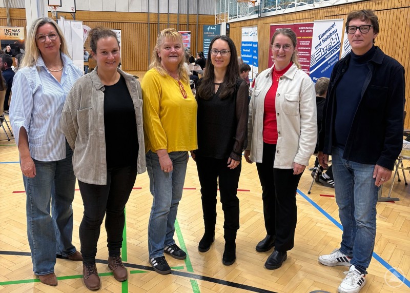 Zufrieden zeigten sich die Verantwortlichen für das neue, gemeinsame Veranstaltungsformat: Rektorin Andrea Stockbauer, Sozialpädagogin Maria Sammer, Studienrätin Susanna Ratschmann, Neureichenaus Bürgermeisterin Kristina Urmann sowie Chiara Löw und Stefan Schuster vom Regionalmanagement FRG (von links nach rechts). Sechs Personen stehen in einer Turnhalle nebeneinander und lächeln in die Kamera, im Hintergrund sind Messestände und Plakate sichtbar.