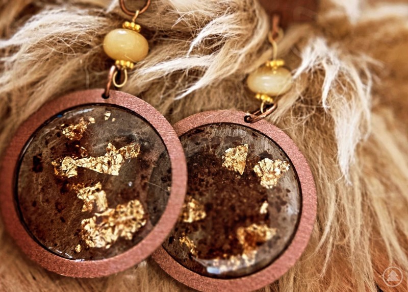 Runde Ohrringe Model Seidelbaits in Braun- und Goldt&ouml;nen auf einem Kunstfell ausgestellt.