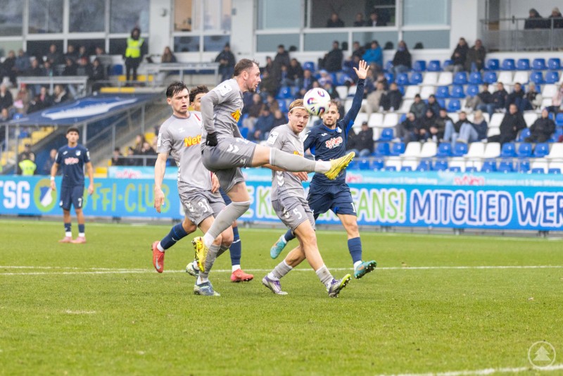 Umkämpfte Strafraumszene im Duell zwischen Hoffenheim II und dem SSV Jahn. Mehrere Spieler kämpfen im Strafraum um einen hohen Ball.