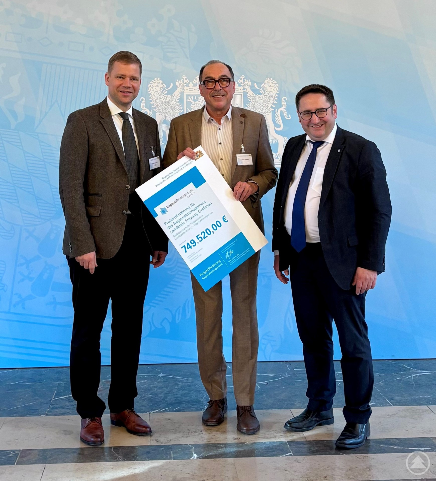 Stellvertretender Landrat Franz Brunner (Mitte) freut sich gemeinsam mit Freyungs Bürgermeister Dr. Olaf Heinrich (links, Kooperationspartner für die Sonderförderung „Konversion“) über die von Staatssekretär Tobias Gotthardt übergebene stattliche Fördersumme für das Regionalmanagement Freyung-Grafenau.