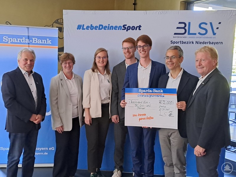 BLSV-Bezirksvorsitzender Otto Baumann mit Vertretern des BC Grün-Weiß Obernzell, Sparda-Bank Vorstandsvorsitzendem Michael Gruber und Walter Knoller. Sechs Personen stehen vor Roll-Ups von Sparda-Bank und BLSV, in der Mitte wird ein symbolischer Scheck überreicht.