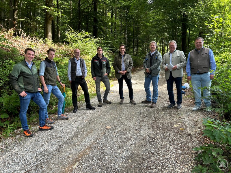 Das neue Walderlebniszentrum in Bodenmais wird ein Gewinn für die ganze Region. Bei einem Ortstermin von MdL Dr. Stefan Ebner informierten Vertreter aus Politik, Verwaltung und Forst über den aktuellen Stand (v.l.): Markus Höhensteiger, Tobias Machnitzke, Dr. Martin Zierhut, Christoph Salzmann, Dr. Stefan Ebner, Sören Timm, Helmut Brunner und Michael Adam. Acht Männer stehen auf einem geschotterten Waldweg im Grünen. Sie tragen überwiegend legere oder forstbezogene Kleidung und blicken in die Kamera – im Hintergrund dichter Mischwald.