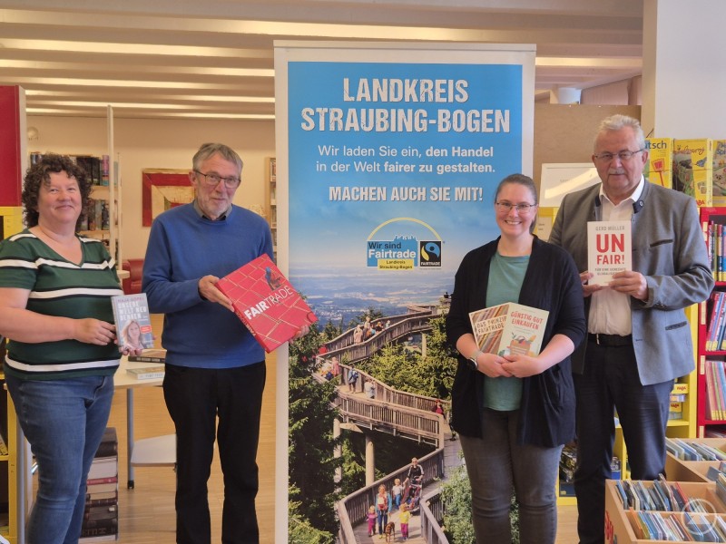 Landrat Josef Laumer und Bernhard Suttner übergeben Bücher an die Bücherei Mallersdorf-Pfaffenberg. Vier Personen halten Bücher in den Händen und stehen in einer Bücherei vor einem Banner mit der Aufschrift „Landkreis Straubing-Bogen – Machen auch Sie mit!“.