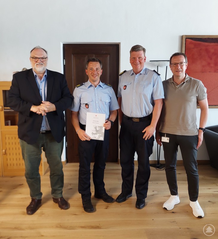 Oberbürgermeister Jürgen Dupper (links) gratuliert Florian Dillinger (2. v. l.) zur Ernennung zum Örtlichen Einsatzleiter, mit Stadtbrandrat Andreas Dittlmann und Ordnungsamtsleiter Erik Linseisen (rechts). Vier Männer stehen in einem Büroraum, zwei davon in Feuerwehruniform. Einer hält eine Urkunde in der Hand. Die Szene zeigt eine offizielle Ehrung oder Ernennung.