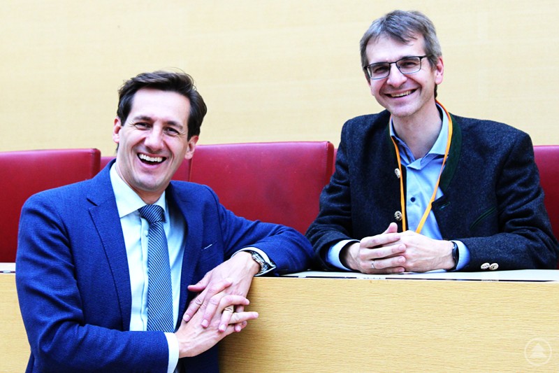 Gute Nachrichten in Sachen Glasfaserausbau in Spiegelau überbringen Landtagsabgeordneter Dr. Stefan Ebner (l.) und Bürgermeister Karlheinz Roth. Zwei Männer in Anzügen sitzen nebeneinander an einem hellen Tisch und lächeln in die Kamera.