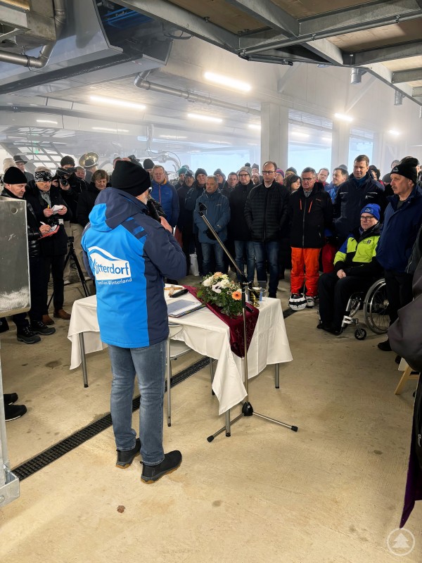 Geschäftsführer des Zweckverbands Wintersportzentrum Mitterfirmiansreut-Philippsreut, Bernhard Hain, spricht vor zahlreichen Gästen Geschäftsführer Bernhard Hain spricht bei einer Feierstunde in der Liftstation vor zahlreichen Gästen, die aufmerksam zuhören.