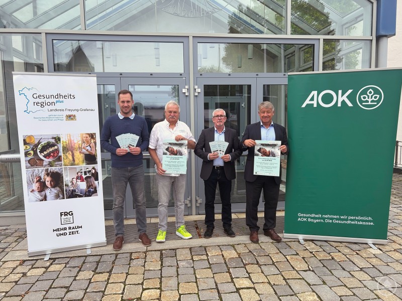 v.l.: René Kurtz (Geschäftsstellenleitung Gesundheitsregion plus Landkreis Freyung-Grafenau), Helmut Dendl (Vorsitzender Bundesverband Gemeinnützige Selbsthilfe Schlafapnoe Deutschland), Christian Mitterdorfer (Fachbetreuer Markt & Gesundheit, AOK-Direktion Bayerwald-Deggendorf), Jürgen Beck (Direktor AOK-Direktion Bayerwald-Deggendorf) Vier Männer stehen vor dem Eingang eines Gebäudes zwischen Roll-Ups der „Gesundheitsregion plus“ und der AOK. Sie halten Flyer und Plakate in den Händen.