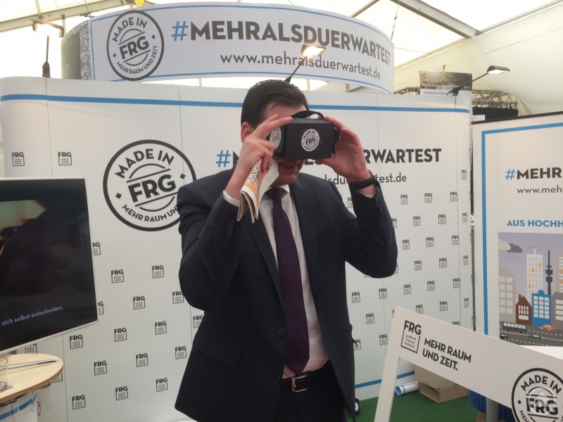 Landrat Sebastian Gruber mit einer 360 Grad-Videobrille beim Betrachten eines Films über Leben in FRG.