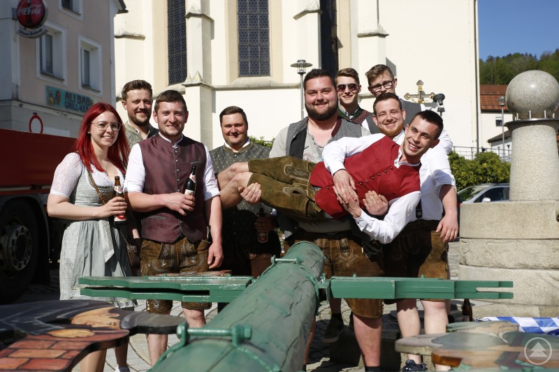 Johann Süß wurde von den Maibaumkrampflern humorvoll „abtransportiert“, nachdem sie den Maibaum erfolgreich zurückgebracht hatten. Maibaumkrampfler in Tracht tragen ihren Kollegen lachend durch Schönberg