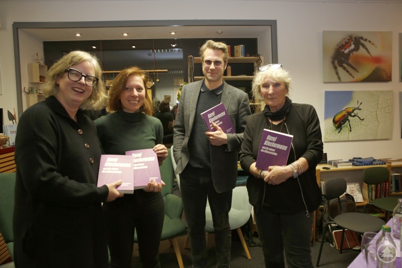 Edith Döringer (l.) und Hannelore Hopfer (r.) freuten sich, über die edition Lichtland das tschechische Werk von Veronika Faktorová und Michal L. Hořejší ins Deutsche für eine Wiederentdeckung Klostermanns und eine Wiedergeburt des gemeinsamen Böhmerwaldes übertragen zu dürfen. Vier Personen stehen in einem Buchladen nebeneinander und halten jeweils ein Exemplar des Buches „Karl Klostermann und die Geburt des Böhmerwaldes“ in den Händen. Im Hintergrund sind Regale sowie großformatige Naturfotos an der Wand zu sehen.