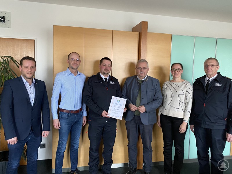 Jürgen Biermeier Landratsamt, Dominik Bachl Landratsamt, Albert Uttendorfer jun., Landrat Josef Laumer, Abteilungsleiterin Stephanie Aumer, Kreisbrandrat Markus Weber von links bei der Übergabe der Ernennungsurkunde. Sechs Personen stehen nebeneinander in einem Büro. In der Mitte hält Albert Uttendorfer eine Urkunde in der Hand, daneben Landrat Josef Laumer und weitere Vertreter des Landratsamtes sowie der Feuerwehr.