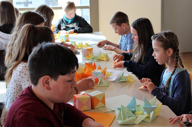 Geometrieunterricht ganz praktisch: Die Viertklässler beim Basteln von Würfeln aus Papier ohne Kleber