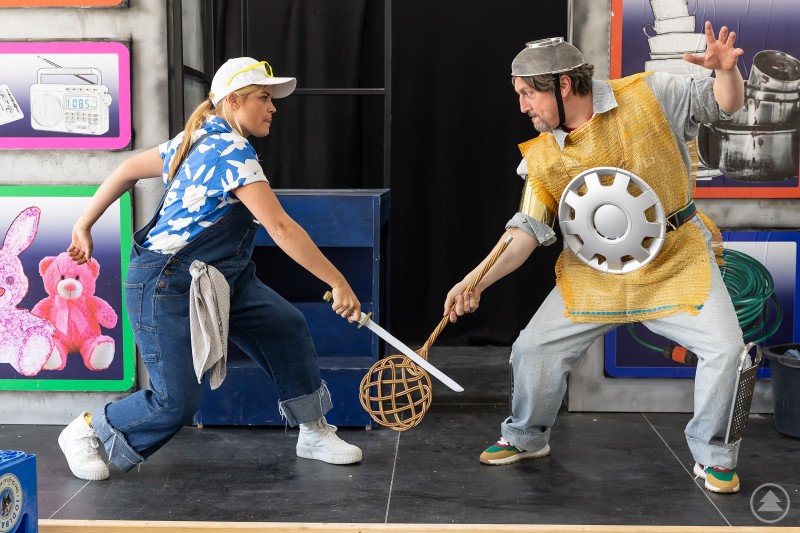 Henriette Heine als Knappe Sancho Pansa und Dieter Fernengel als Don Quijote ziehen zusammen aus, um Abenteuer zu bestehen. Zwei Schauspieler in improvisierten Ritterkostümen führen auf einer Bühne ein humorvolles Duell mit Alltagsgegenständen.