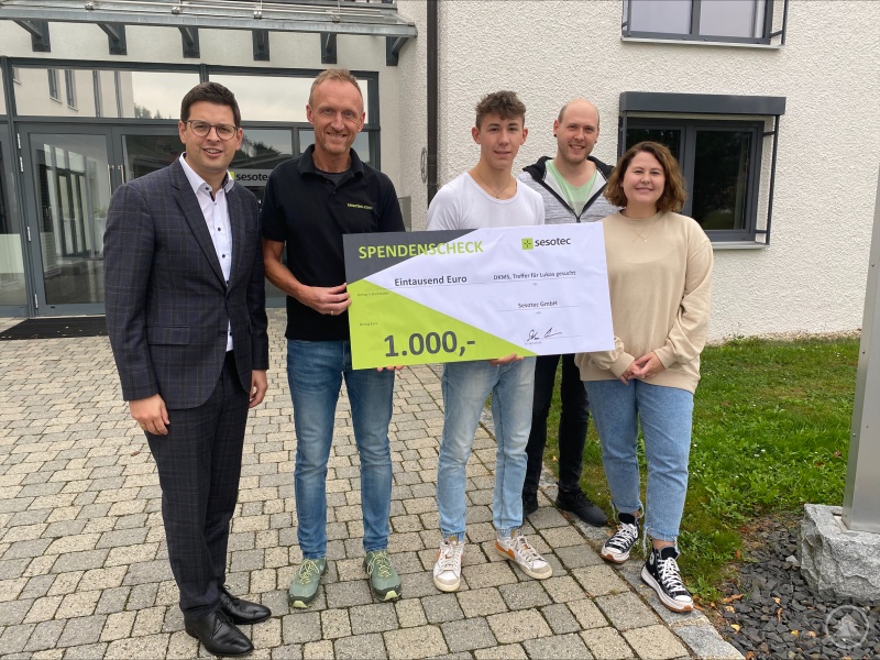 SESOTEC-CEO Stefan Feldmeier übergab einen Scheck in Höhe von 1 000 Euro stellvertretend an Bürgermeister Martin Pichler (l.) sowie (v.r.) Geschwister von Lukas. Auch dieses Geld wird bei der DKMS dafür eingesetzt, Lebensrettung mit den nötigen Mitteln am Laufen zu halten.