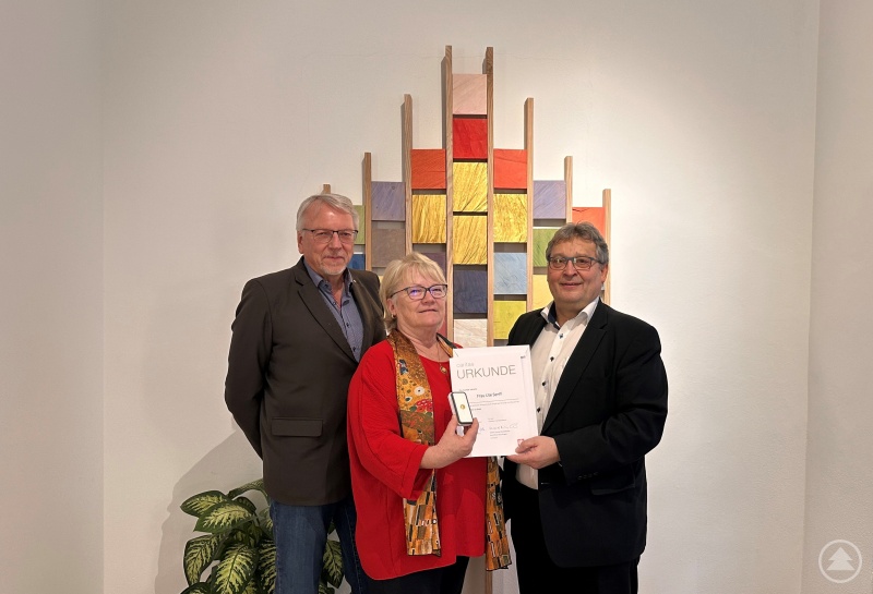 BU: Diakon Konrad Niederländer (r.), bedankt sich für 22 Jahre unermüdlichen Einsatz im Ehrenamt und überreicht Ute Senff das Goldene Ehrenzeichen der Caritas, mit dabei Ehemann Christian Senff.