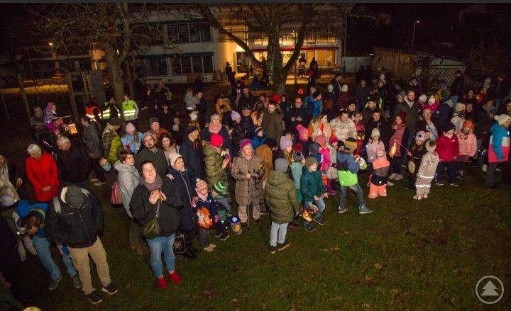Die Kinder des Kindergartens und Krippe Hafenbrädl beim Martinsumzug. Eine große Gruppe von Kindern und Erwachsenen steht am Abend im Freien beisammen. Viele Kinder halten bunte Laternen, während sie sich für den Martinsumzug versammeln.
