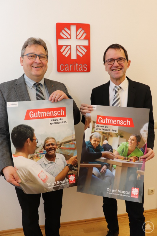 „Sei gut, Mensch!“. Die Vorstände des Diözesan-Caritasverbandes, Michael Endres (re.) und Diakon Konrad Niederländer mit zwei Motiven zur Kampagne. Sie zeigen Menschen, die Verantwortung in der Gesellschaft übernehmen und sich in Caritas-Diensten engagieren.