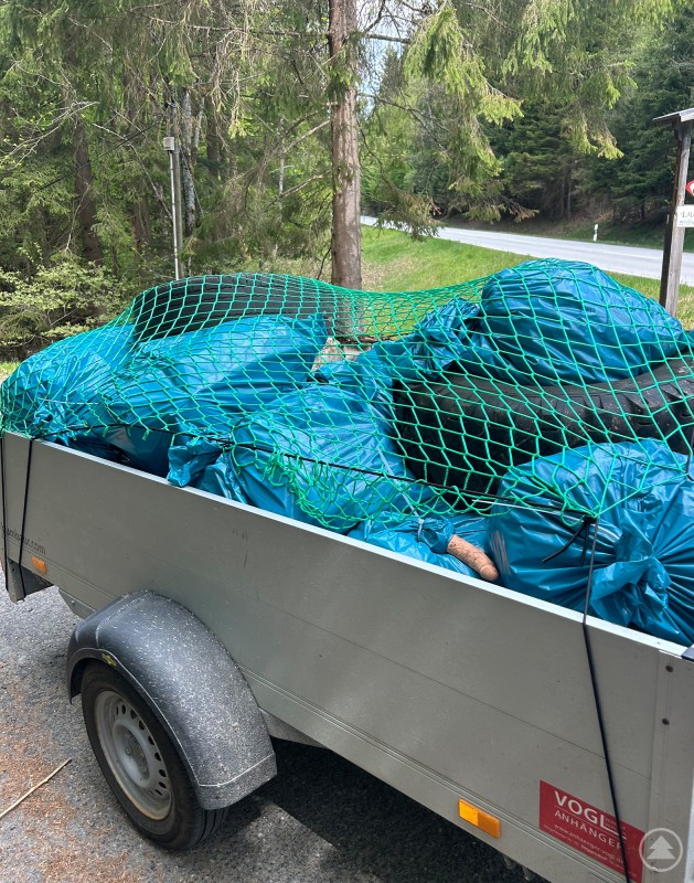 Auch an der B11 zwischen Ludwigsthal und Bayerisch Eisenstein kam viel Unrat zusammen. Ein Anhänger ist mit zahlreichen blauen Müllsäcken beladen, die bei einer Sammelaktion im Nationalpark Bayerischer Wald zusammengetragen wurden.