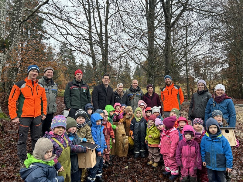 Spechthöhlen samt Skulptur sollen Waldkindern vermitteln, wie wichtig es ist, dass auch im genutzten Forst „leben und leben lassen“ auf lange Sicht Vorteile erbringt. Hotelzimmer für den Baumeister des Waldes eröffneten (hinten v.l.) Markus Würstl als stellvertretender Forstbetriebsleiter FB Bodenmais, Tobias Schropp von der Fachstelle Waldnaturschutz, Christoph Salzmann, Bereichsleiter Forsten sowie Martin Pichler, Wolfgang Kreuzer (hinten ab 6.v.l.), Kindergartenleiterin Birgit Bauer, der Revierleiter Forstrevier Klingenbrunn Mathias Knippl und das Kindergartenpersonal samt ihren kleinen Buntspechten