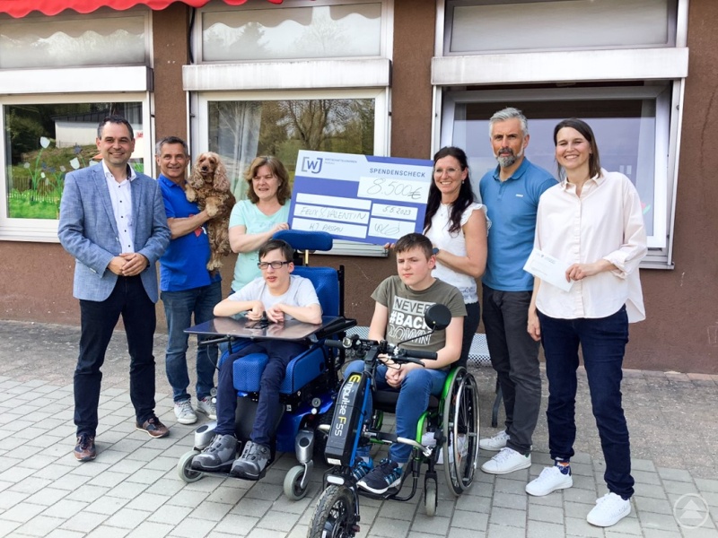 Daniel Schmidbauer und Bettina Göttl übergeben den Spendenscheck an Felix und Valentin (jeweils dahinter die Mütter der Beiden). Mit dabei waren Landrat Raimund Kneidinger und Karl Bischof.
