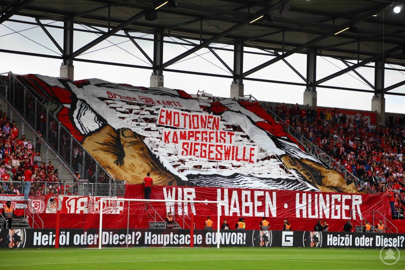 Große Fan-Choreografie auf der Tribüne mit einer kämpferischen Botschaft und Spruchband