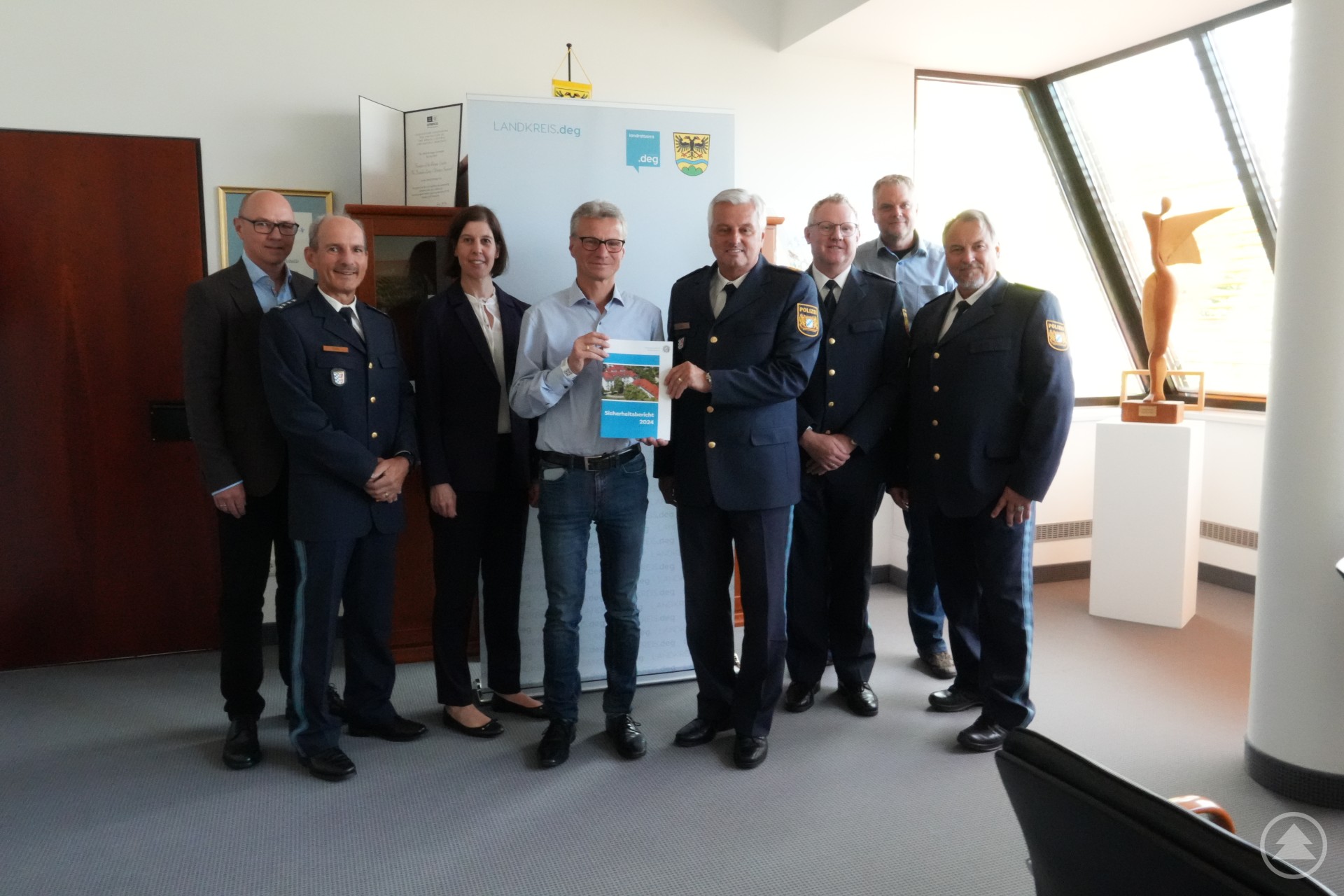 Polizeivizepräsident Werner Sika übergibt zusammen mit leitenden Vertretern der Polizei die Kriminalstatistik 2024 an das Landratsamt Deggendorf. Gruppenfoto mehrerer Vertreter der Polizei und des Landratsamts Deggendorf bei der Übergabe der Kriminalstatistik 2024 in einem Büro.