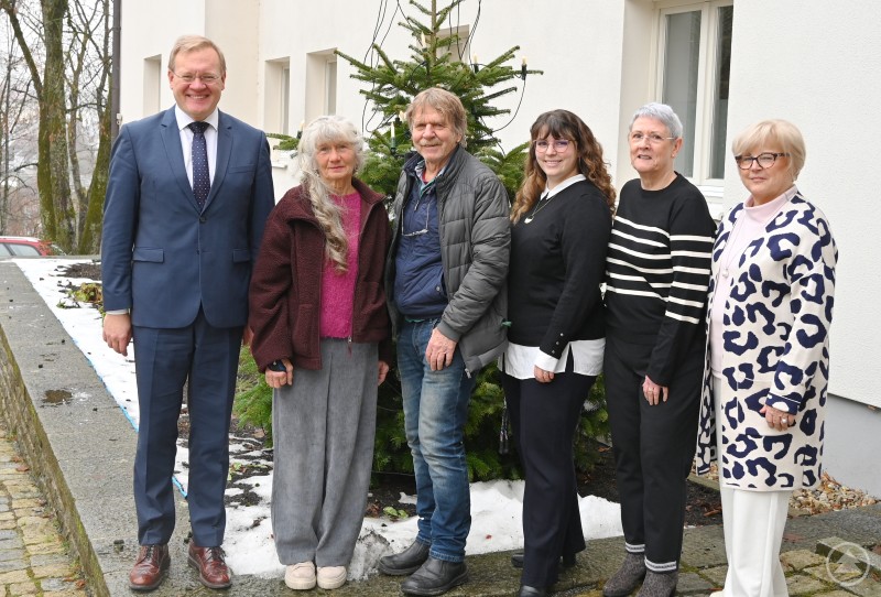 Die neugewählte Vorstandschaft (von links) Dr. Mikko Klein, Gabi Hanner, Jochen Michel, Kulturreferentin Gabriela Rauscher, Gabriele Henrich und stellvertretende Landrätin Helga Weinberger, die Landrat Sebastian Gruber vertrat. Gruppenfoto vor einem Gebäude im Winter: Sechs Personen stehen vor einem geschmückten Tannenbaum und posieren für ein Erinnerungsfoto.