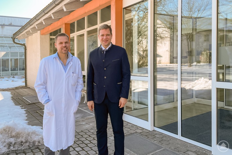Chefarzt Prof. Tobias Schmidt-Wilcke l. und Bezirkstagspräsident Dr. Olaf Heinrich. Chefarzt Prof. Tobias Schmidt-Wilcke und Bezirkstagspräsident Dr. Olaf Heinrich stehen vor dem Eingang des Bezirksklinikums Mainkofen und posieren für ein gemeinsames Foto.