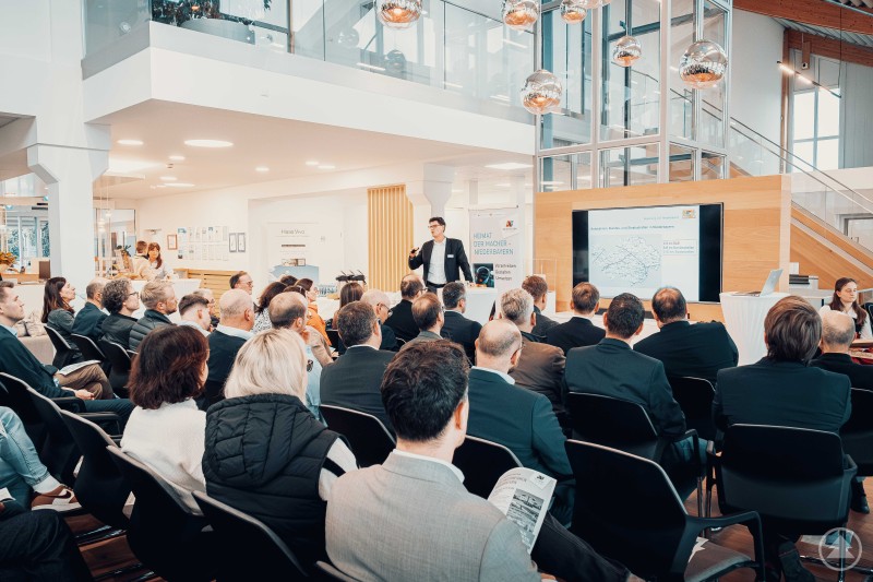 Stefan Leitner, Sachgebietsleiter Straßenverkehr an der Regierung von Niederbayern, stellte die Schwerpunkte der Straßenverkehrsplanung in Niederbayern vor. Vortragssituation mit zahlreichen Zuhörern in einem hellen Veranstaltungsraum, ein Referent präsentiert Inhalte vor großem Publikum.